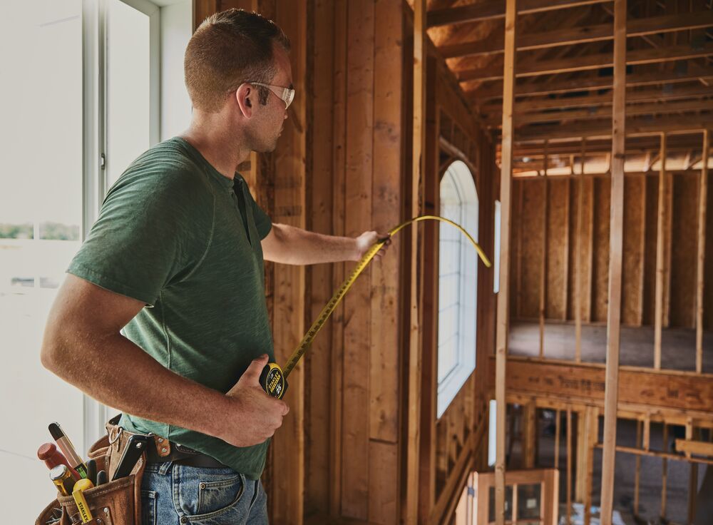 25 foot FATMAX classic tape measure being used by a person in a construction site.